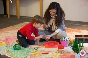 Mother and child cooperating to design Christmas tree ornaments.