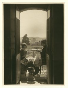 Two Palestinian women seated on a balcony and making Palestinian point lace. The Old City of Jerusalem is in the background. Source: American Colony (Jerusalem) – Congress Library.