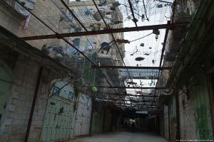 Shuhada Street in Hebron. Palestinian residents have installed nets to keep the garbage that settlers who live above throw onto the street below. Photo courtesy of Palestine Image Bank.