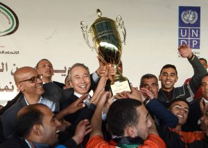 H.E. Takeshi Okubo, Ambassador of Japan, and UNDP Representative, Roberto Valent, holding the championship cup.