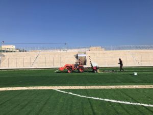 Installing artificial turf in the Jenin stadium.