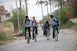 Children riding their bicycles in the streets of Jericho.