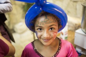 A girl from Khan al-Ahmar Bedouin community playing with balloons before a Ramadan Iftar. Photo by Iuna Vieira, courtesy of the European Union.