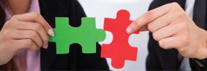 Two hands joining puzzle pieces. © Andrey Popov | Dreamstime.com.