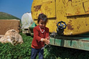 Using water from a tank near her family tent, Hannan, 5 years old, washes her hands in the Al-Maleh area in the northern Jordan Valley. Photo ©UNICEF-SoP/2019.